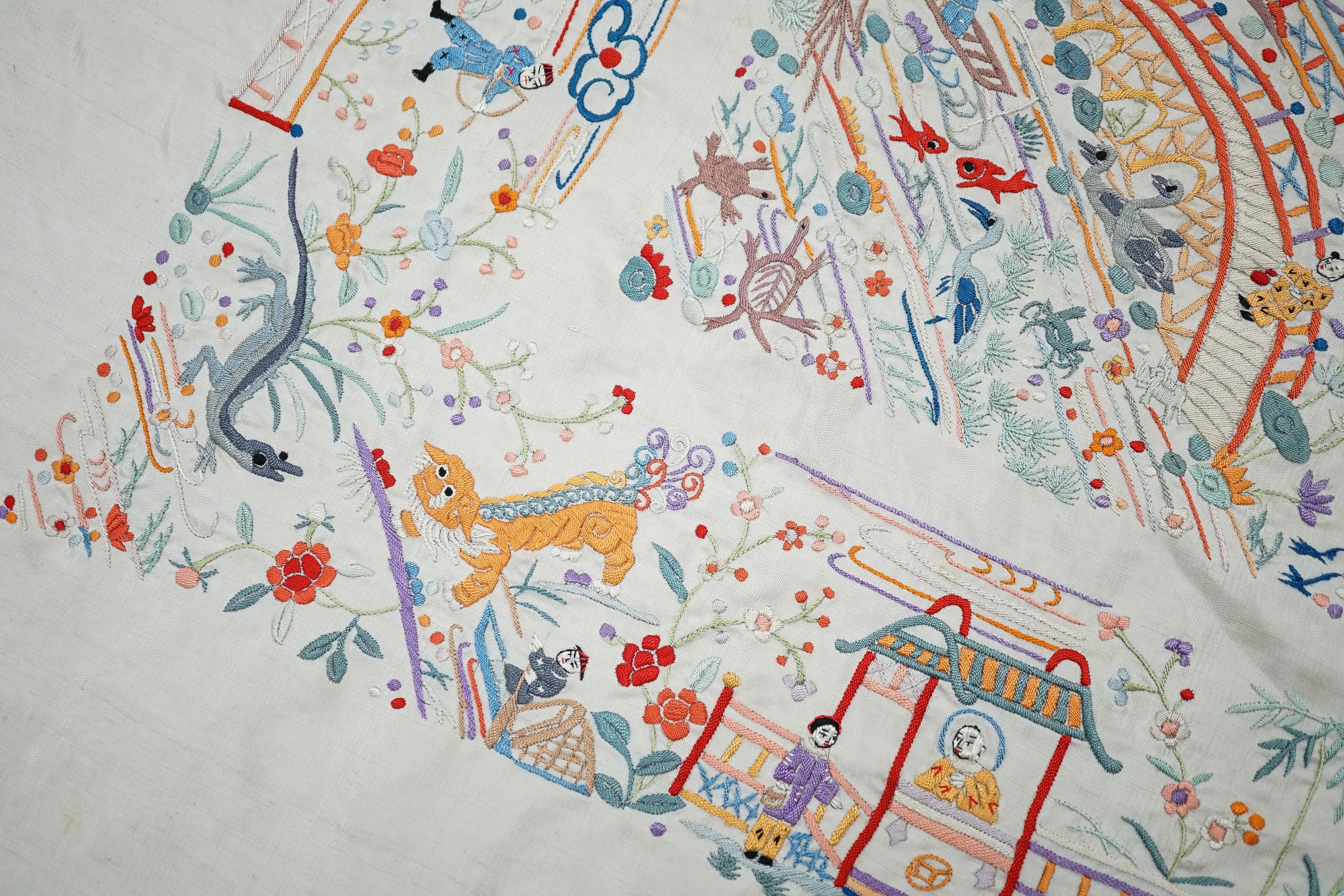 A Chinese cream silk shawl with fine multi coloured all over embroidery depicting figurative scenes and animals